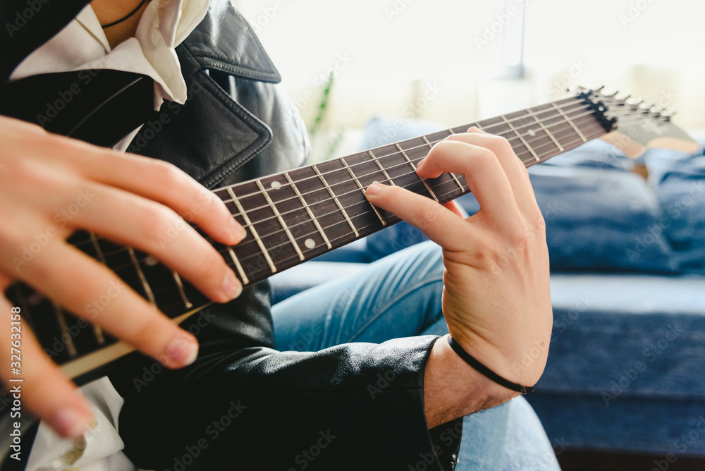 Fototapeta premium Electric guitar teacher teaching how to place fingers to play a chord.