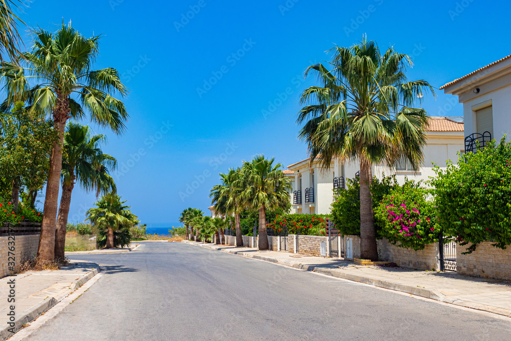 Cyprus. Protaras. The streets of Protaras. Walking the streets. Tourist resorts of Cyprus. Palm trees grow along the edges of the road. Roads of Cyprus on a sunny day. Mediterranean resorts.