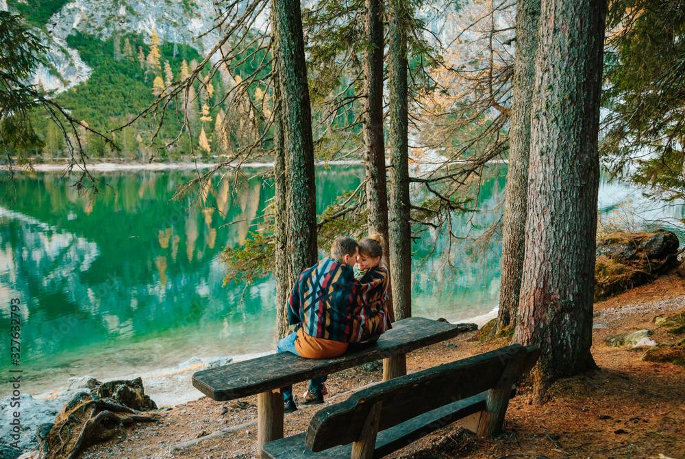 Φωτογραφία two young people near the famous lake Braies in Italy with Dolomites mountains i