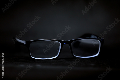 Black glasses isolated on a black background. Big brother is watching. Abstract.	
