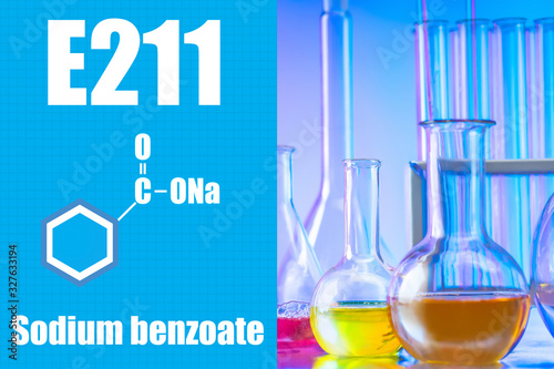Sodium benzoate. Å211. Production of an expectorant. Concept - Sodium benzoate in pharmacology. Medical laboratory with test tubes. Test tubes with colored liquids. Formula of sodium benzoate.