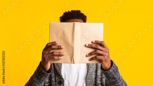 Young african student pretended as if he was reading a book