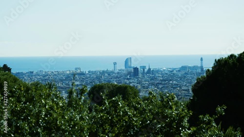 Wide view of beautiful cityscape of Barcelona with green nature in the foreground at a sunny day. photo