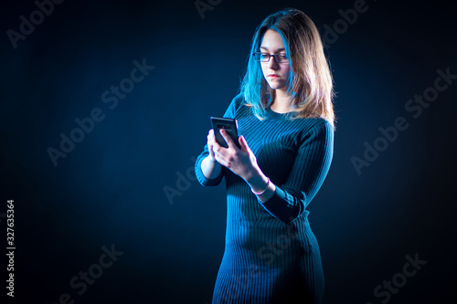 Girl with a phone on a dark...