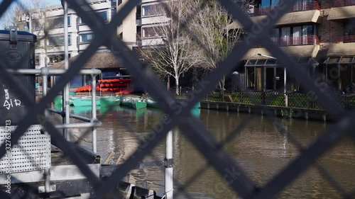 Artistically Shot made behind a wood fence, of the River Cam, river that gives name to the city of Cambridge , England. photo