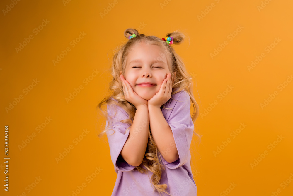 portrait of a happy child girl isolate on a yellow background, space for text portrait of a happy child girl isolate on a yellow background, space for text