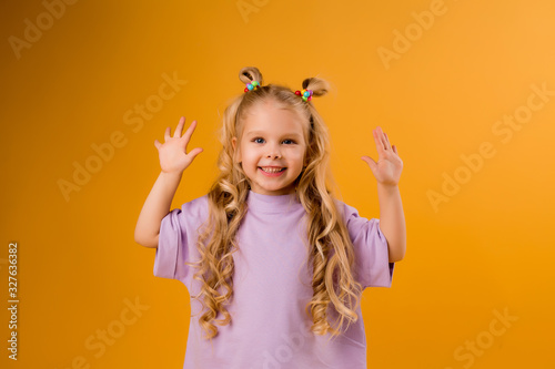 portrait of a happy child girl isolate on a yellow background  space for text