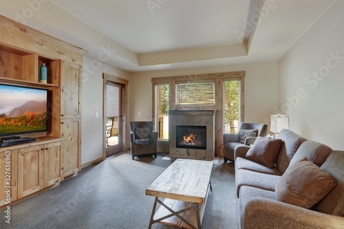 Living room interior with fireplace, natural wood furniture and brown cozy sofa. photo