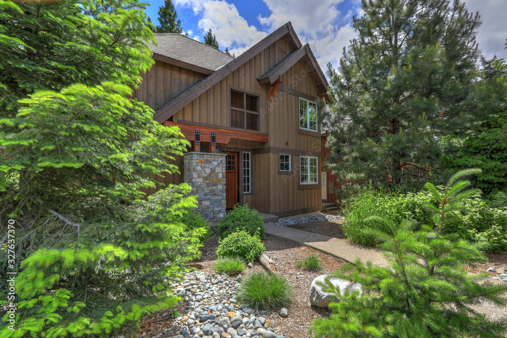 Cedar brown mountain home with great landscaping and rocks, modern lines of the front exterior.