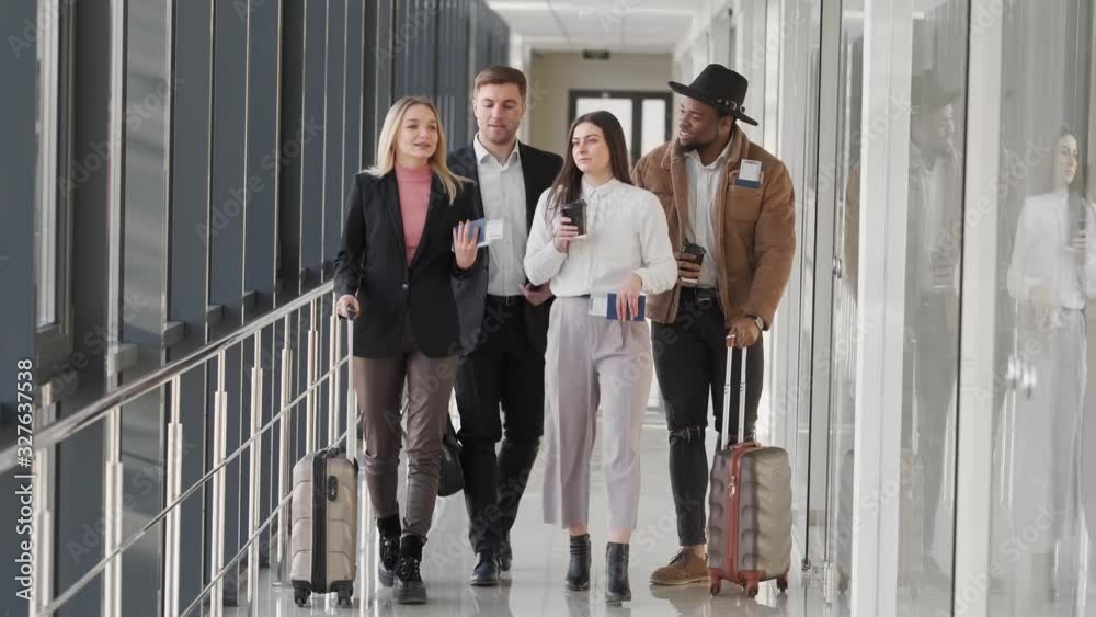 Business people go with coffee and tickets down the hall Business people go with coffee and tickets down the hall