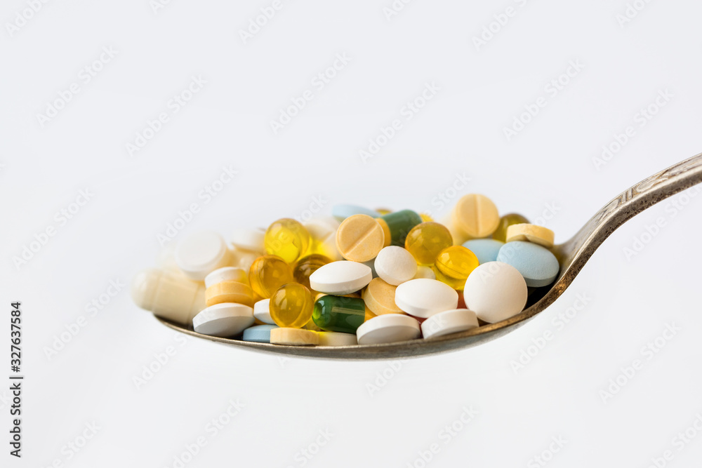 Assorted pharmaceutical medicine pills, tablets and capsules in a spoon on white background. Healthcare concept. Assorted pharmaceutical medicine pills, tablets and capsules in a spoon on white background. Healthcare concept.
