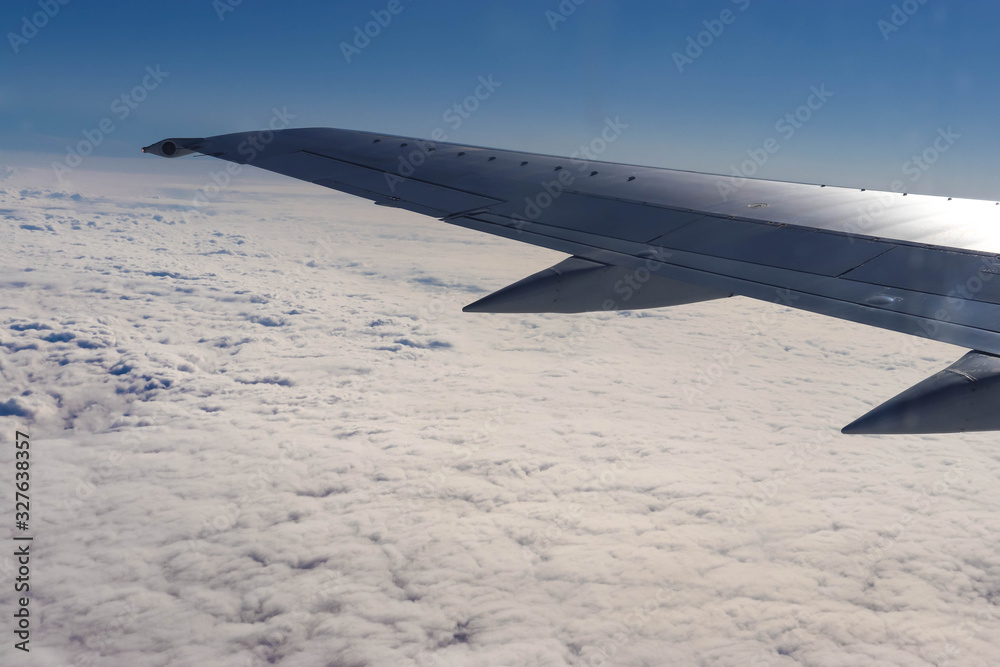 Fototapeta premium Photo of a plane wing on sunny day