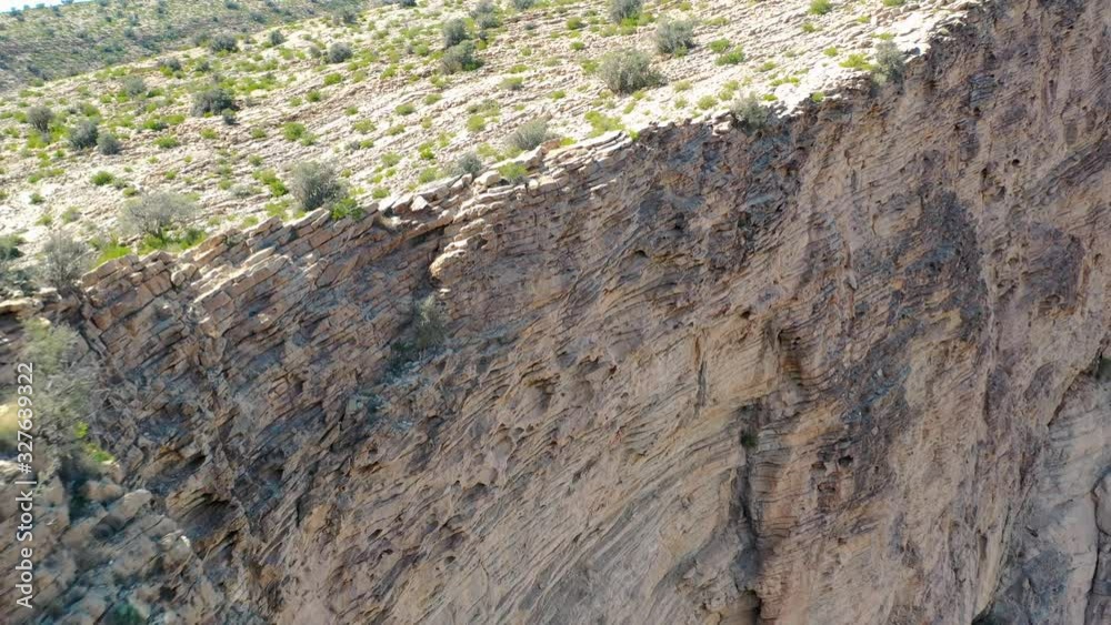 Close up fly away view over a geological layer formed rock cliff in the Oman region. Close up fly away view over a geological layer formed rock cliff in the Oman region.