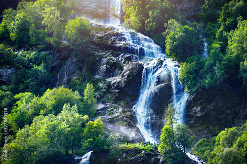 Panoramic beautiful deep forest waterfall in norway near blue ocean. Waterfalls mountain view close up.