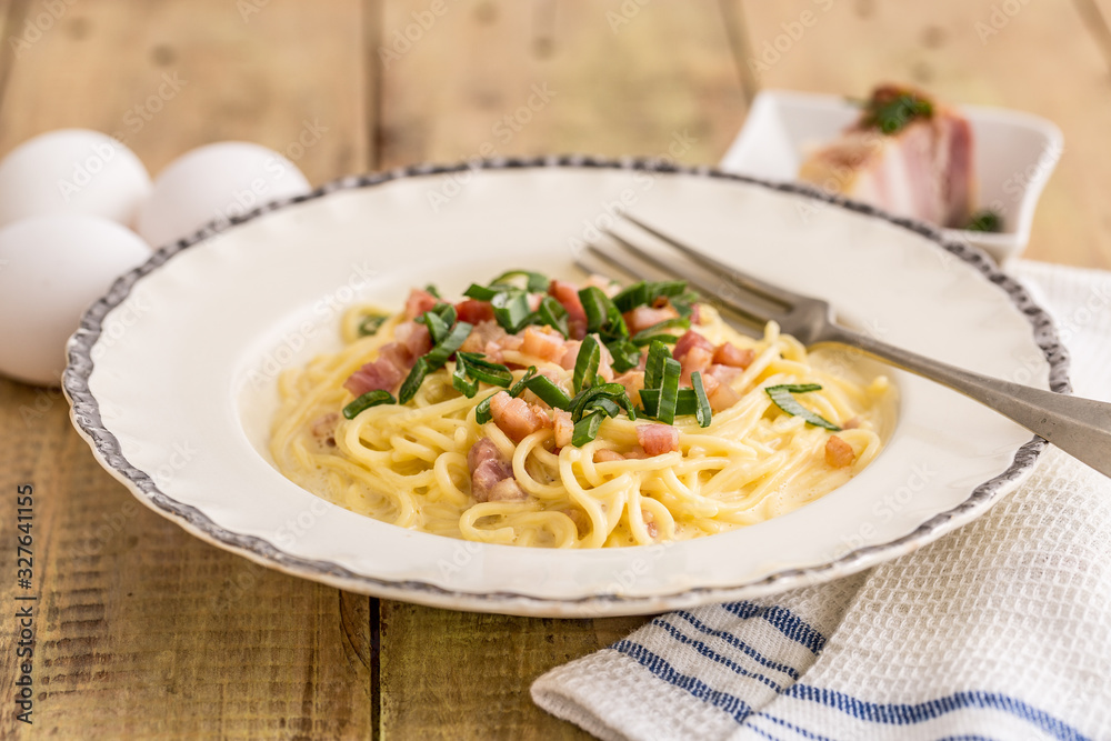 spaghetti with bacon on a wooden table