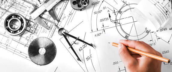 Engineer technicial drawings and mechanical parts engineering industry work project paper prints. Projectant hand with pencil, measuring tools on table.