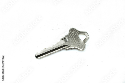 A shiny house key, close up, isolated on a clean, white background.  Shot in macro. © Peter