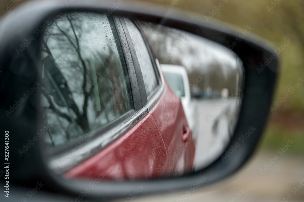 Viewing the side of a wet car in the side mirror