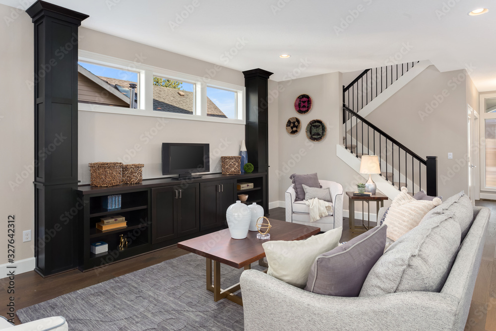 Fototapeta premium Living room interior in new home with built-in shelves, coffee table, couch, pillows, and lamp. 