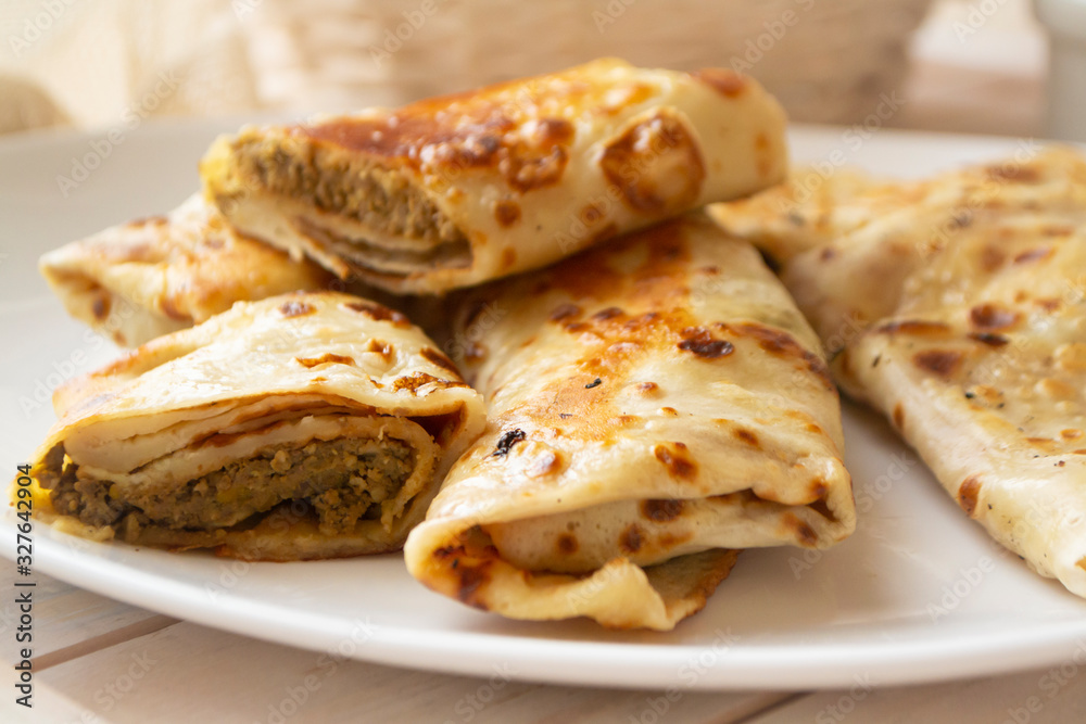 rolled delicious crepes with minced liver and meat pate on white plate, close up rolled delicious crepes with minced liver and meat pate on white plate, close up