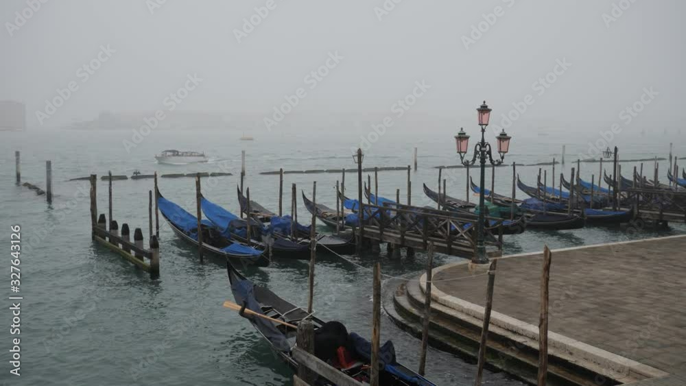 Empty gondolas moored in the misty harbor of Venice near St Mark's Square after the cancelled Carnival Empty gondolas moored in the misty harbor of Venice near St Mark's Square after the cancelled Carnival