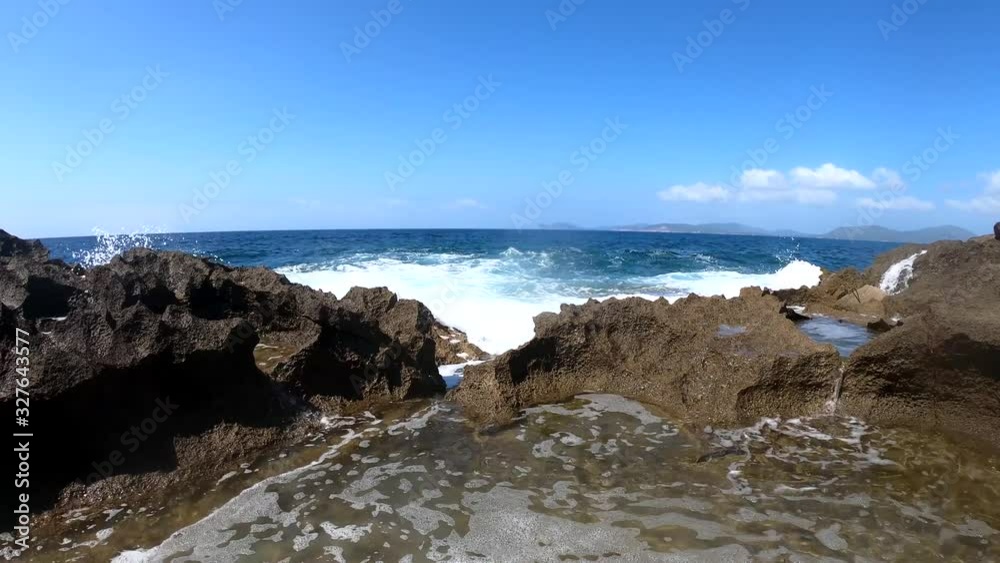 Waves by Alghero rocky shore under a clear sky Waves by Alghero rocky shore under a clear sky