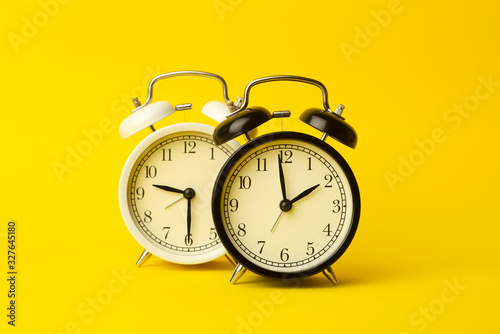 Time background concept. Vintage classic alarm clock on yellow empty background. Time management concept