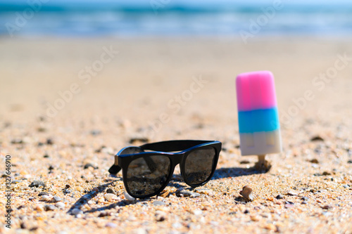 Ice cream with sunglasses on the beach with copying area