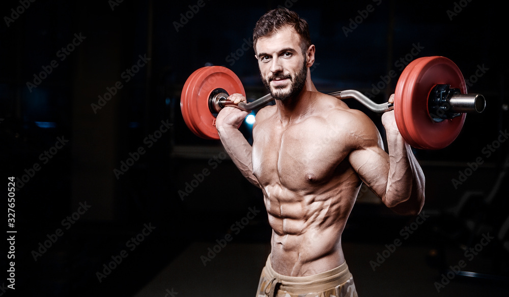 Bodybuilder strong man pumping up abs muscles