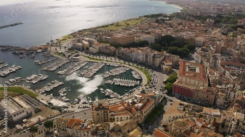 Flight over the harbour of Palermo early sunny morning. Busy traffic on the waterfront. Yacht parking. Sicily, Italy. May 2019. Aerial look-up shot.