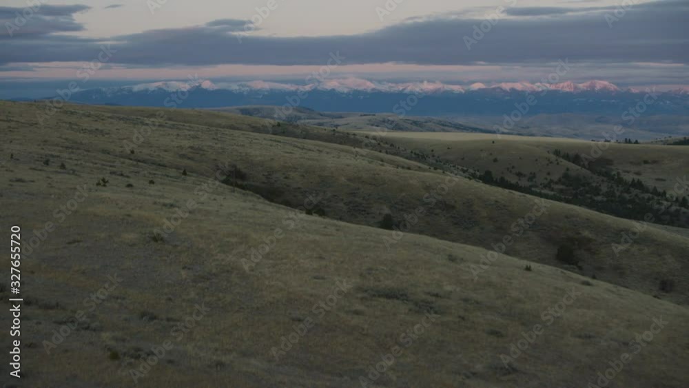 The early morning sunrise highlights the snow-covered summits of the Spanish Peaks in the Madison mountain Range near Bozeman, Montana The early morning sunrise highlights the snow-covered summits of the Spanish Peaks in the Madison mountain Range near Bozeman, Montana