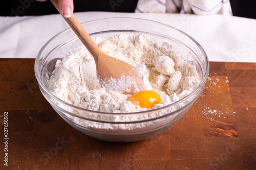 Mujer amasando masa para galletas de chocolate en tabla de madera con rodillo masa en bola