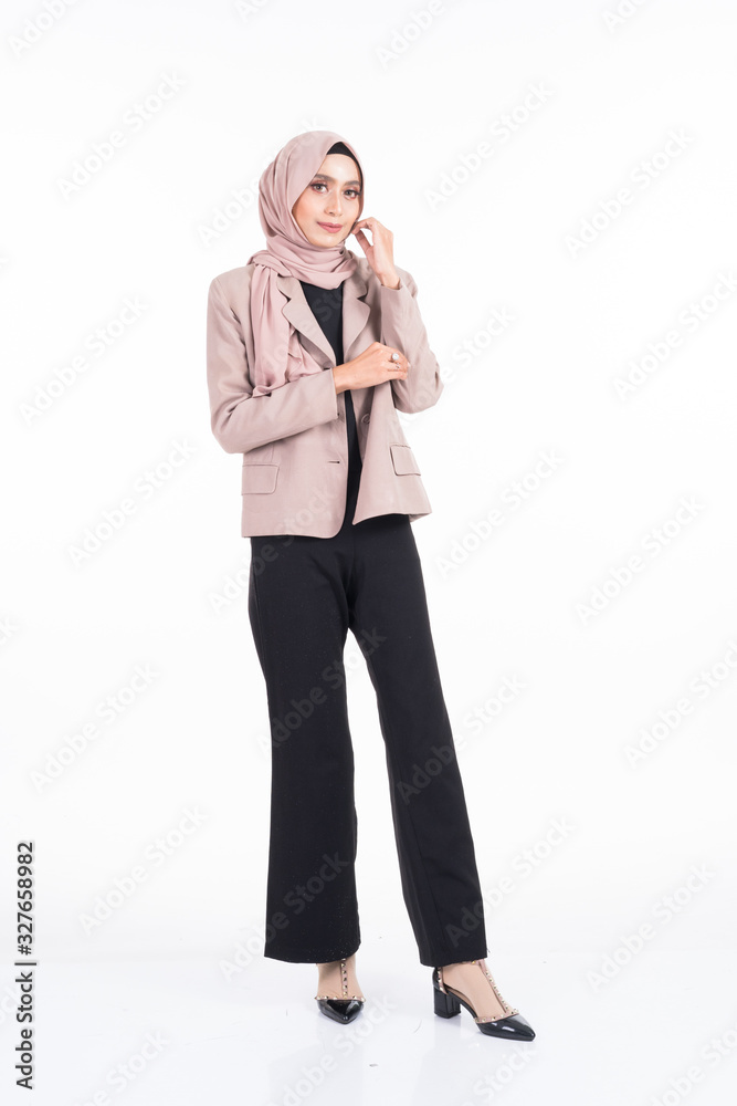 Full length portrait of a beautiful Muslim female model in a hijab and officewear isolated on grey background. Hijab and Muslim fashion lifestyle concept Full length portrait of a beautiful Muslim female model in a hijab and officewear isolated on grey background. Hijab and Muslim fashion lifestyle concept