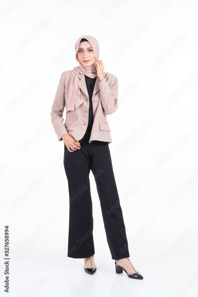 Full length portrait of a beautiful Muslim female model in a hijab and officewear isolated on grey background. Hijab and Muslim fashion lifestyle concept Full length portrait of a beautiful Muslim female model in a hijab and officewear isolated on grey background. Hijab and Muslim fashion lifestyle concept