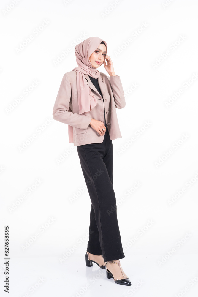 Full length portrait of a beautiful Muslim female model in a hijab and officewear isolated on grey background. Hijab and Muslim fashion lifestyle concept Full length portrait of a beautiful Muslim female model in a hijab and officewear isolated on grey background. Hijab and Muslim fashion lifestyle concept