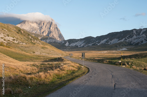 Winding road on campo imperatore leading to mountain corno grande in background at autumn morning, Abruzzo, Italy 