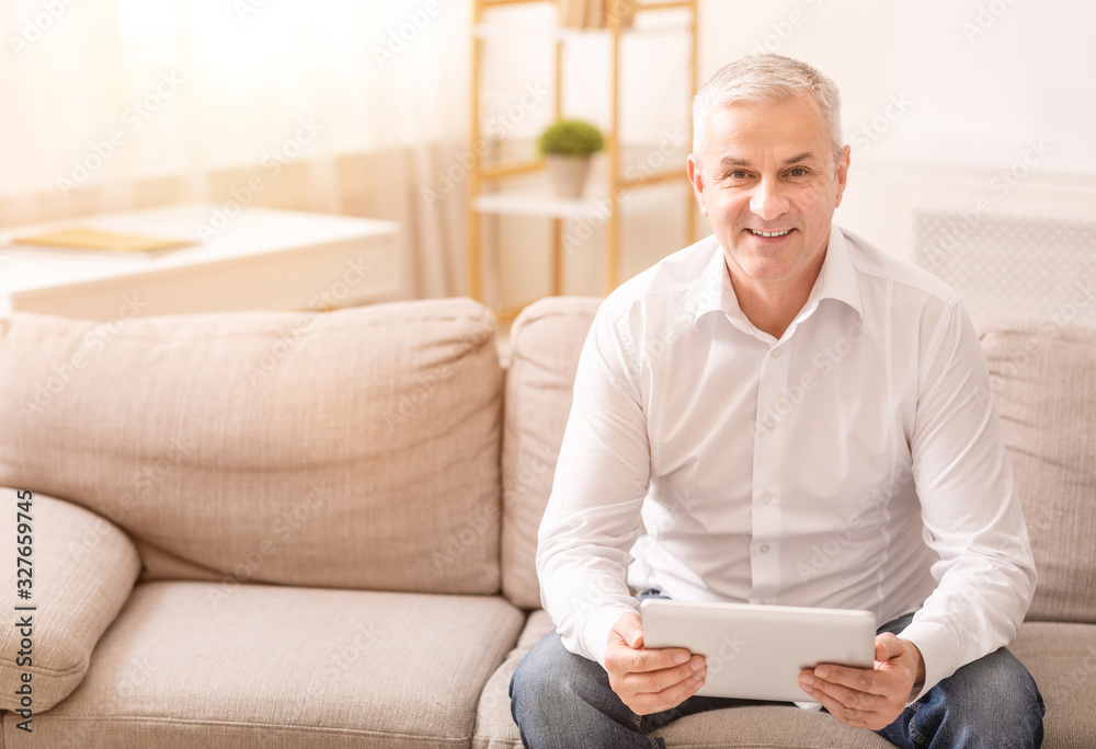 Senior man using digital tablet looking at camera Senior man using digital tablet looking at camera