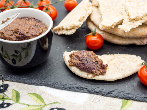 mediterranean appetizer of olive paste and homemade pita bread with cherry tomatoes photo