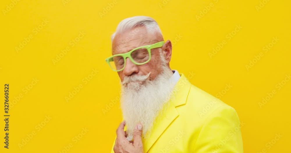 Senior man hipster with funny colored outfit on colored backgrounds