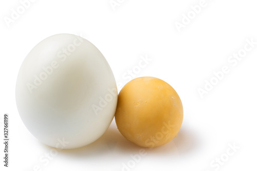 peeled boiled egg, on a white background, lies next to a round yolk, food concept