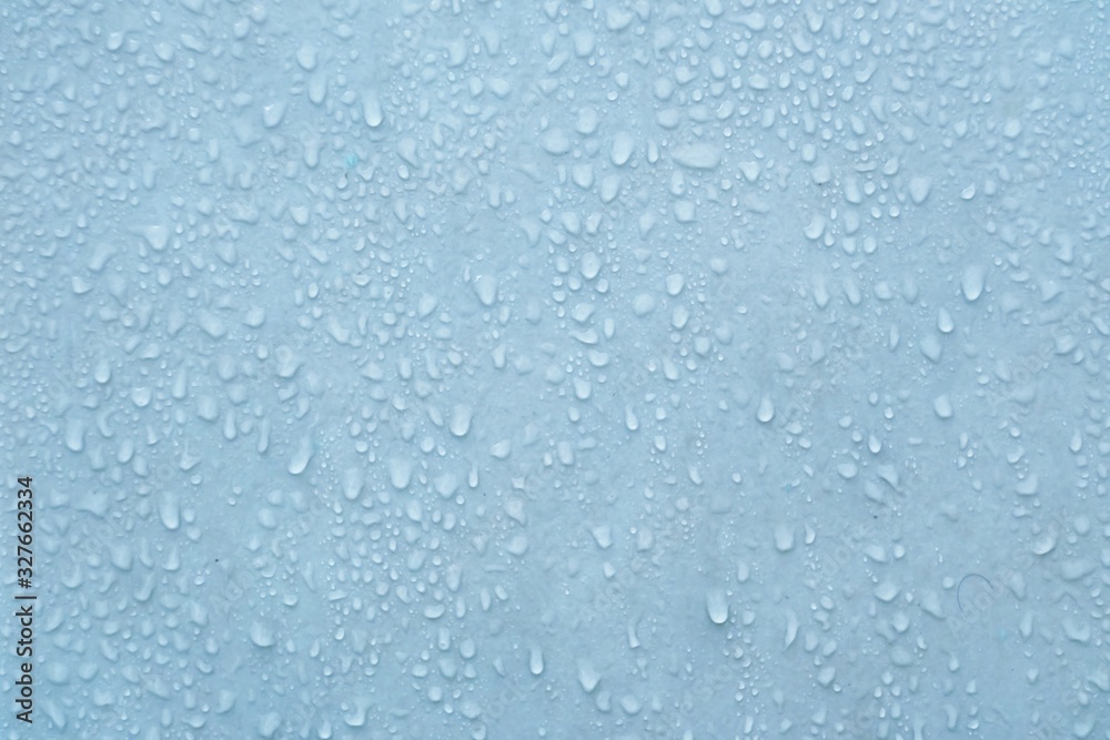 In selective focus many droplets on blue wall with bright wet color for backdrop texture