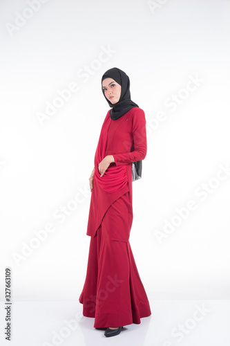 Beautiful female Asian model in various poses wearing a red Malaysian traditional wear isolated on white background. Beauty and fashion concept. Full length portrait