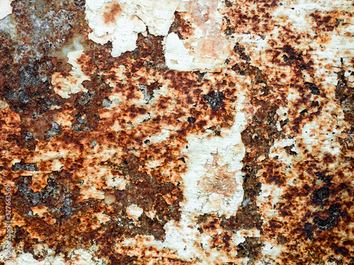 Corroded white metal background. Rusty corrosion. Rusty metal surface with streaks of rust. Brown, black and orange rust and dirt on white enamel. Rusted brown and white abstract texture.