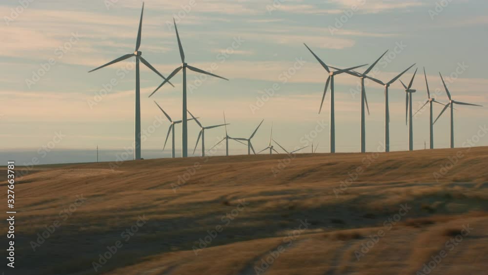 Tracking shot of energy producing wind turbines in Oregon