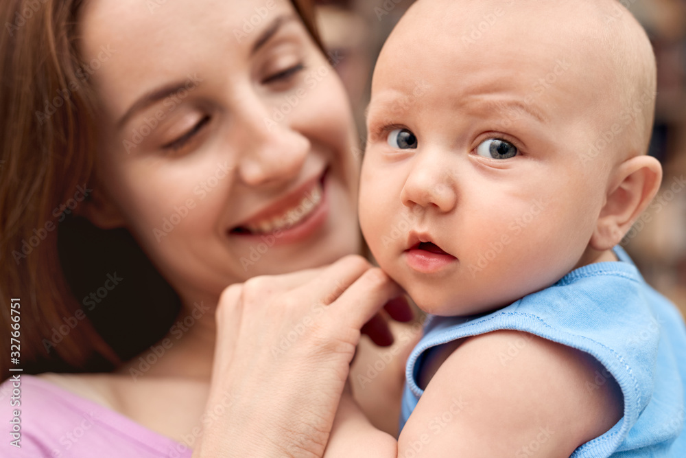 Young adult woman looking at her little newborn offspring Young adult woman looking at her little newborn offspring