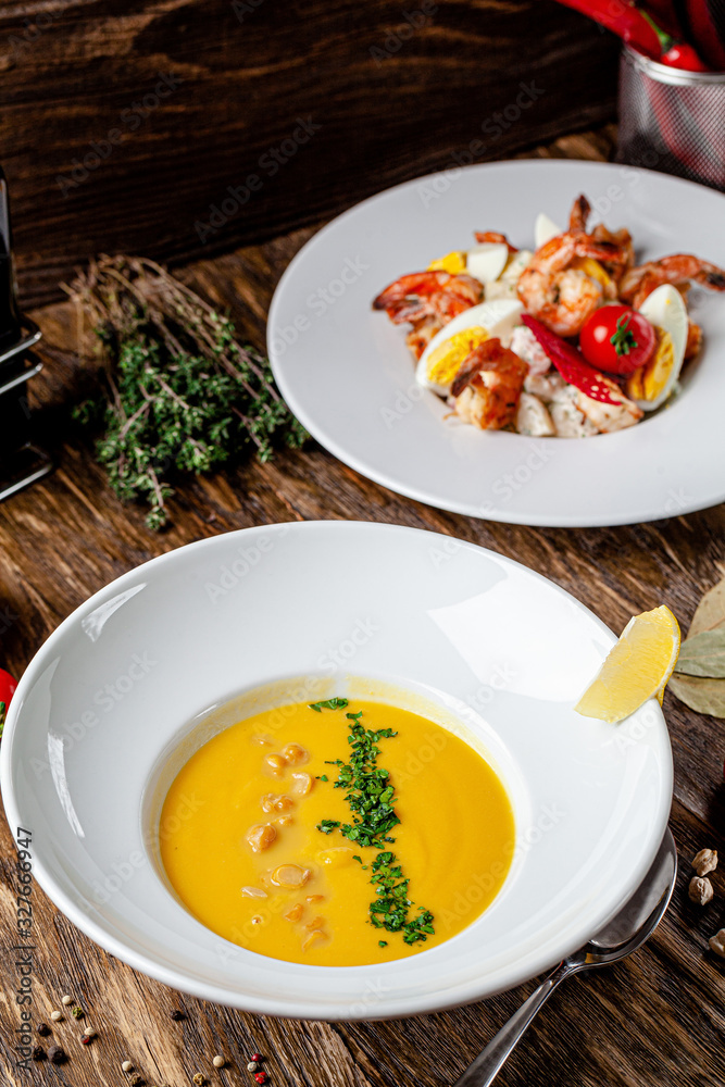 Serbian cuisine. Macedonian cream soup of chickpeas, carrots, onions, garlic, with chicken. Serving dishes in a restaurant in a white plate. background image, copy space text Serbian cuisine. Macedonian cream soup of chickpeas, carrots, onions, garlic, with chicken. Serving dishes in a restaurant in a white plate. background image, copy space text