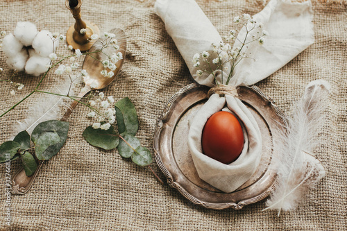 Photography Stylish Easter brunch table setting with egg in easter bunny napkin