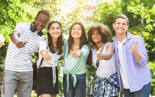 Happy Multicultural Teens Posing Together Outdoors And Showing Thumb Up