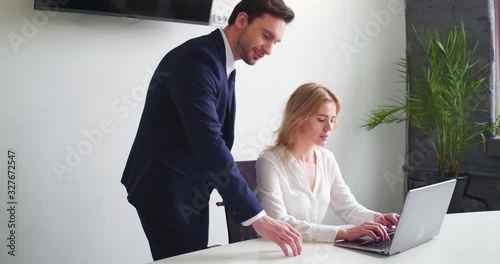 Businessman trying to Sexually Harassing Female Colleague while she is working on laptop at her office