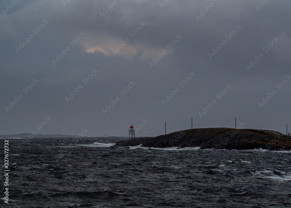 Lighthouse with waves and clouds, surrounded with ocean